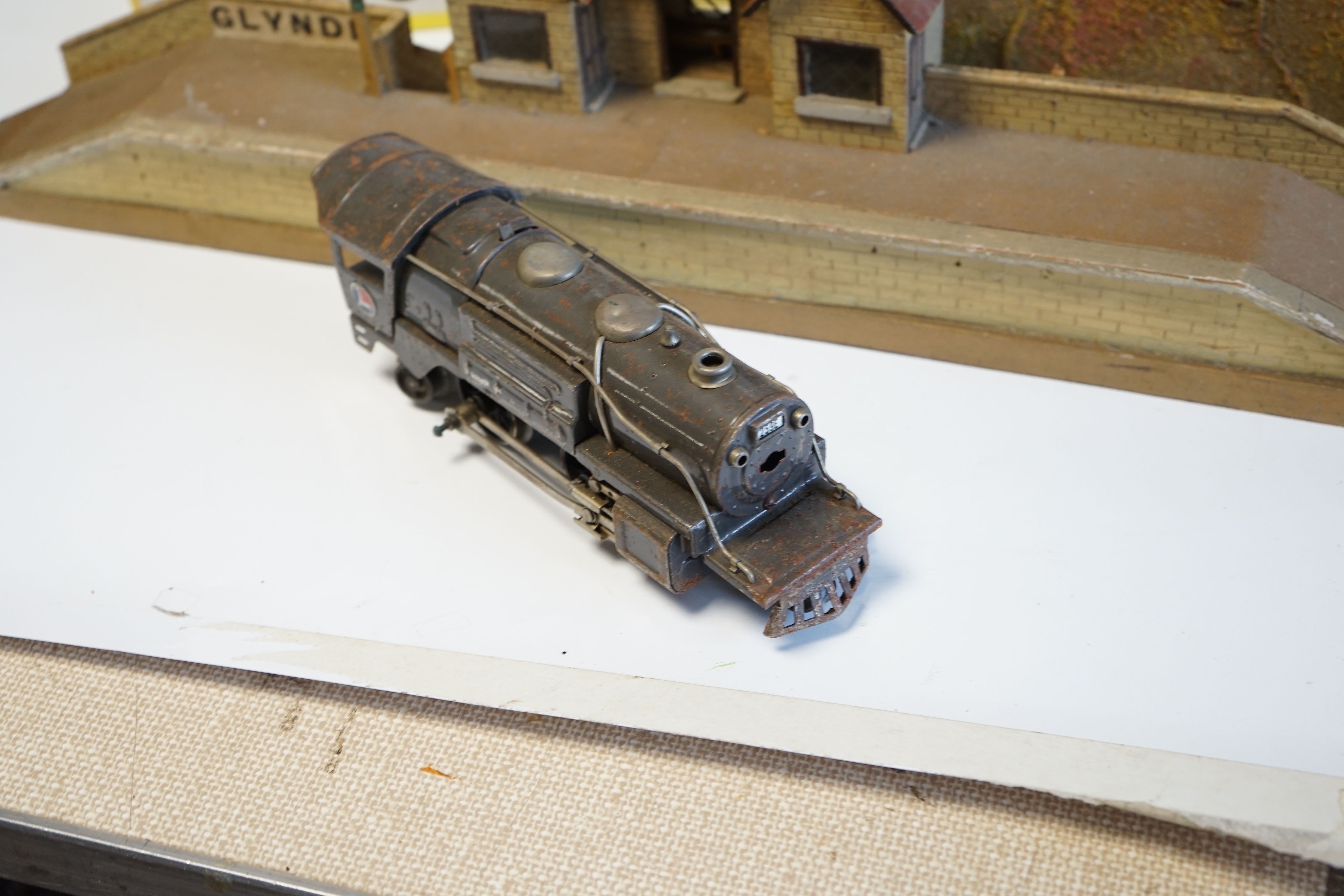 A Lionel 3-rail electric US outline tender locomotive, together with three tinplate bogie Pullman Cars and a small quantity of Hornby 3-rail track sections, a Hornby tunnel and a scratch-built Through railway station